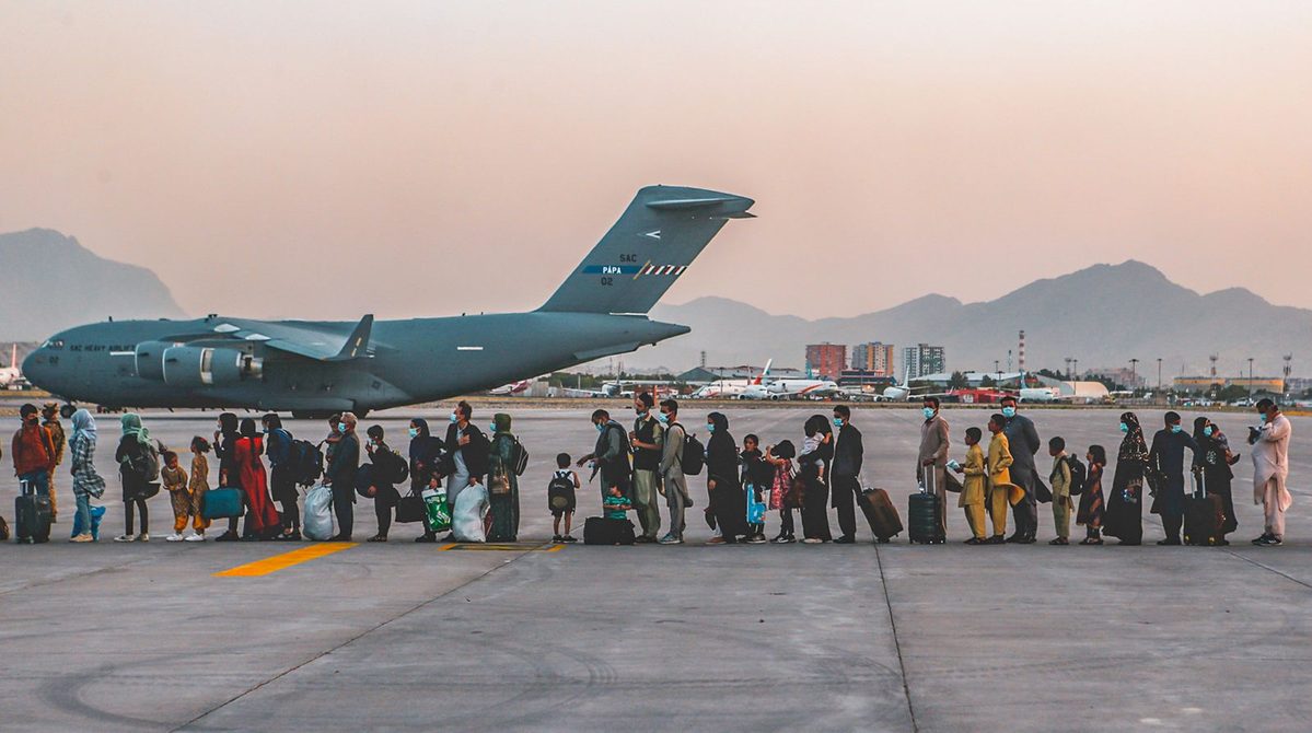 Evacuees wait to board a C-17 at Hamid Karzai International Airport in Kabul during the August 2021 airlift. Photo: Sgt. Isaiah Campbell / U.S. Marine Corps, via Wikimedia Commons, public domain.
