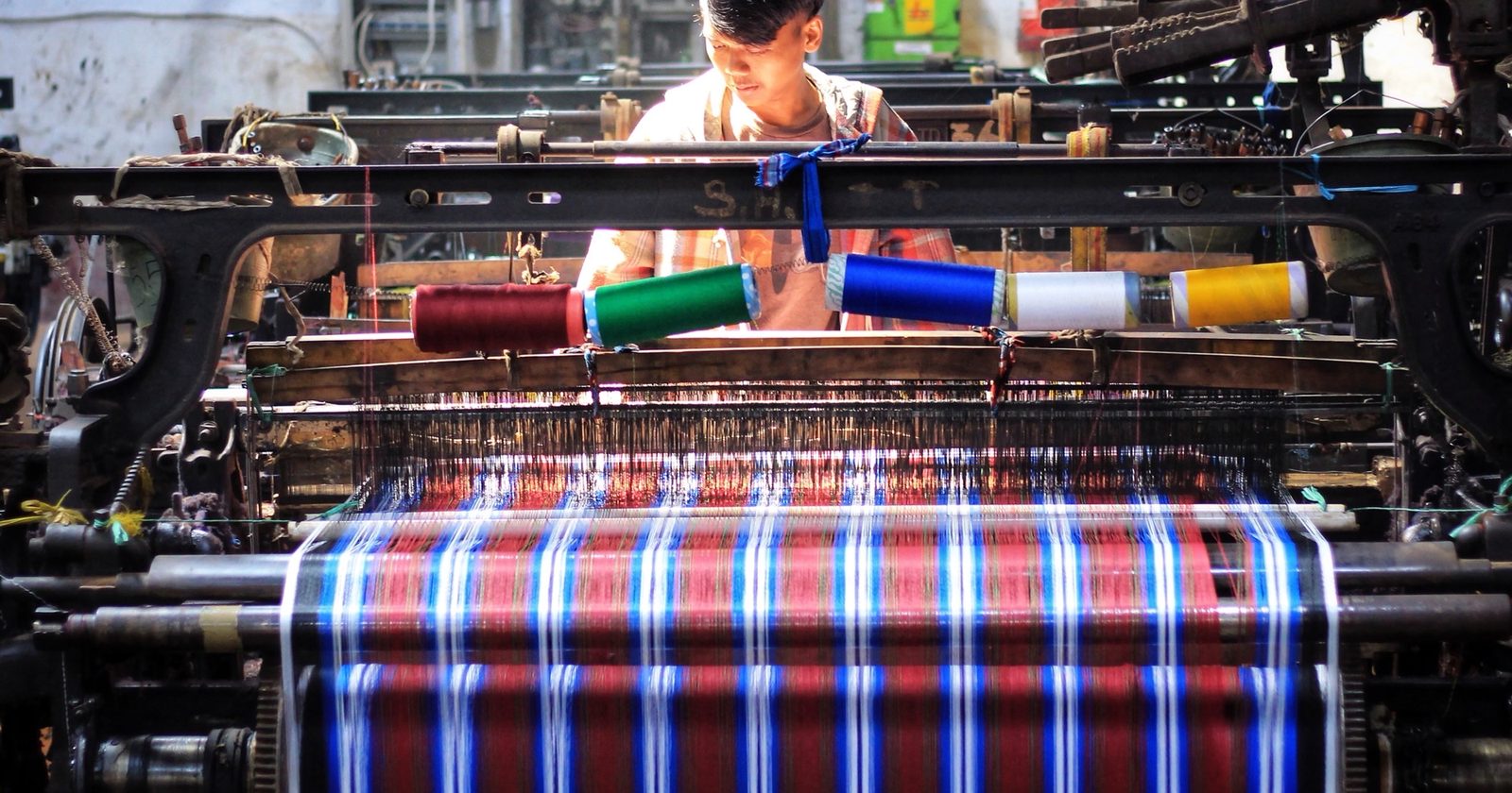 A weaver at a traditional non-machine loom in Majalaya, West Java, July 2019. Photo: Reival Akbar Rivawan via Wikimedia Commons, CC BY-SA 4.0.